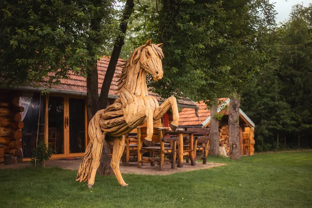Drevený kôň pri drevených chalupách v areáli